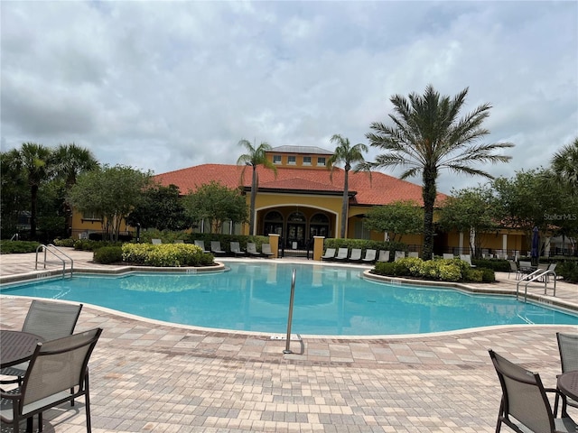 927 Orange Cosmos Blvd, Davenport, FL 33837 - community pool featuring a patio