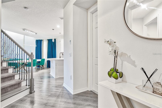 1147 Wildmeadow Run, Winter Park, FL 32792 - foyer entrance featuring wood finished floors, a textured ceiling, stairs, and baseboards