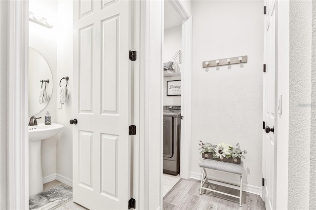 1147 Wildmeadow Run, Winter Park, FL 32792 - bathroom featuring washer / clothes dryer, wood finished floors, baseboards, and a sink