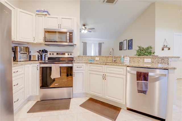 15303 SW 52nd Cir, Ocala, FL 34473 - kitchen with stainless steel appliances, a sink, vaulted ceiling, a ceiling fan, and light stone countertops