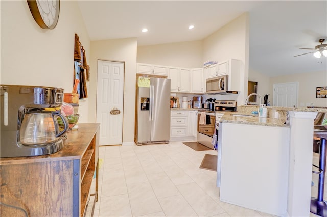 15303 SW 52nd Cir, Ocala, FL 34473 - kitchen featuring appliances with stainless steel finishes, a peninsula, lofted ceiling, light stone countertops, and a breakfast bar