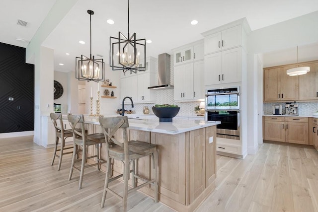 13791 Abberwick Dr, Orlando, FL 32832 - kitchen with wall chimney range hood, a chandelier, light wood-type flooring, decorative backsplash, and a sink