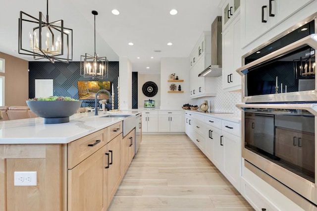 13791 Abberwick Dr, Orlando, FL 32832 - kitchen featuring stainless steel double oven, wall chimney exhaust hood, a chandelier, a sink, and light brown cabinets