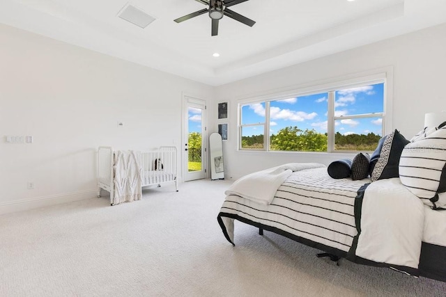 13791 Abberwick Dr, Orlando, FL 32832 - bedroom featuring access to exterior, a tray ceiling, baseboards, light carpet, and a ceiling fan