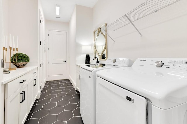 13791 Abberwick Dr, Orlando, FL 32832 - laundry area featuring washer and clothes dryer, dark tile patterned floors, and cabinet space
