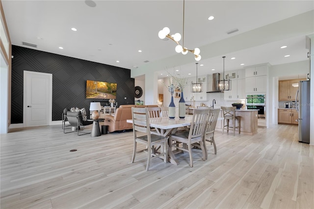13791 Abberwick Dr, Orlando, FL 32832 - dining space with an accent wall, a chandelier, light wood-style flooring, wallpapered walls, and recessed lighting