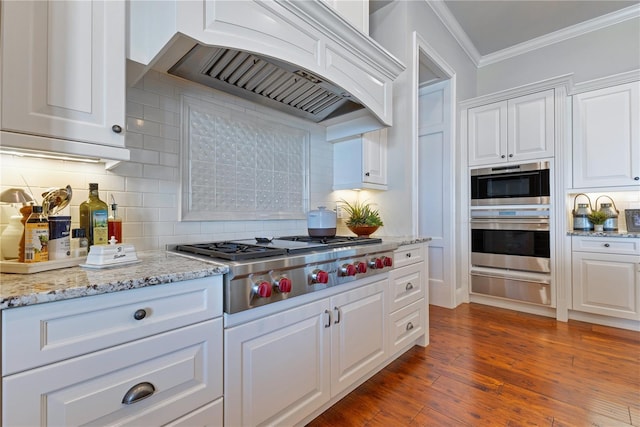 10845 Bayshore Dr, Windermere, FL 34786 - kitchen featuring a warming drawer, appliances with stainless steel finishes, premium range hood, ornamental molding, and white cabinetry