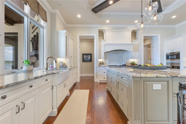 10845 Bayshore Dr, Windermere, FL 34786 - kitchen featuring a sink, dark wood-style floors, light stone counters, ornamental molding, and backsplash