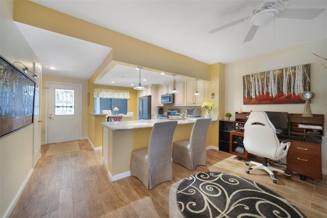 1074 Kensington Park Ct Unit 101, Altamonte Springs, FL 32714 - kitchen featuring stainless steel appliances, light wood finished floors, ceiling fan, a desk, and baseboards