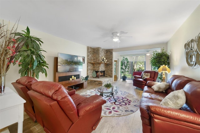 1074 Kensington Park Ct Unit 101, Altamonte Springs, FL 32714 - living area featuring a large fireplace, a ceiling fan, and light wood-style floors