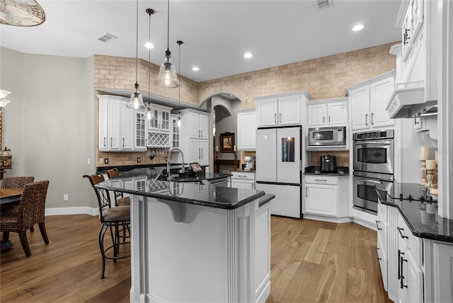 190 Osprey Hammock Trl, Sanford, FL 32771 - kitchen with stainless steel appliances, a sink, light wood finished floors, a kitchen bar, and recessed lighting
