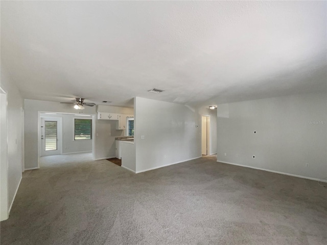 300 Ave E SE, Winter Haven, FL 33880 - unfurnished living room with carpet floors, a ceiling fan, and baseboards
