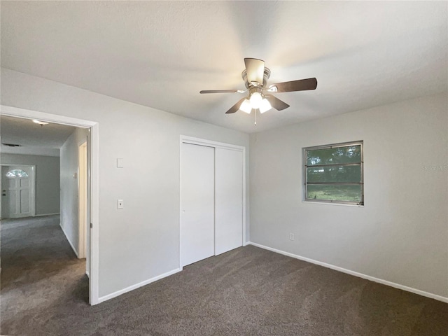 300 Ave E SE, Winter Haven, FL 33880 - unfurnished bedroom with dark carpet, baseboards, a closet, and a ceiling fan