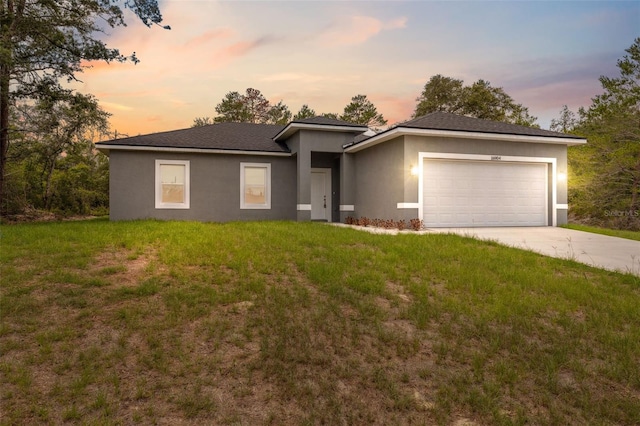 16904 SW 30th Avenue Rd, Ocala, FL 34473 - view of front of property featuring stucco siding, an attached garage, driveway, and a lawn