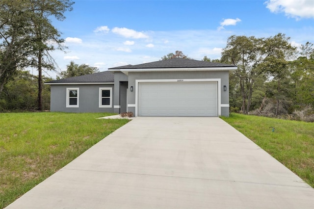 16904 SW 30th Avenue Rd, Ocala, FL 34473 - prairie-style house featuring stucco siding, a garage, driveway, a front lawn, and a shingled roof