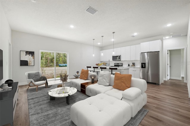 16904 SW 30th Avenue Rd, Ocala, FL 34473 - living room featuring recessed lighting, wood finished floors, a textured ceiling, and baseboards