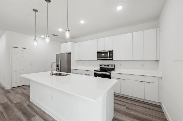 16904 SW 30th Avenue Rd, Ocala, FL 34473 - kitchen with appliances with stainless steel finishes, a sink, dark wood finished floors, white cabinetry, and a center island with sink