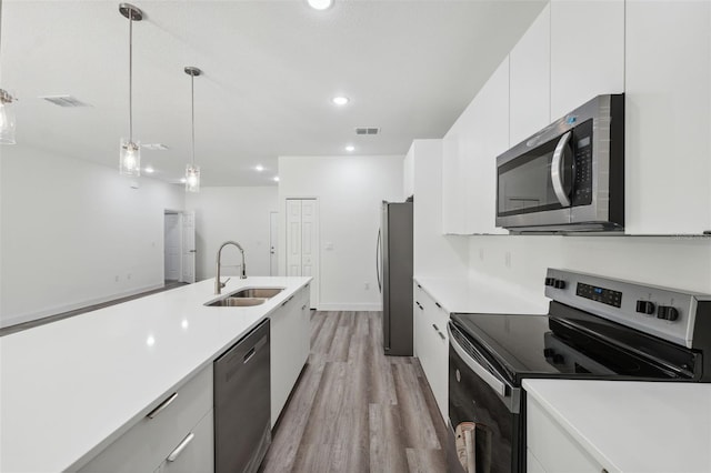 16904 SW 30th Avenue Rd, Ocala, FL 34473 - kitchen with stainless steel appliances, light wood-style flooring, a sink, white cabinets, and light countertops