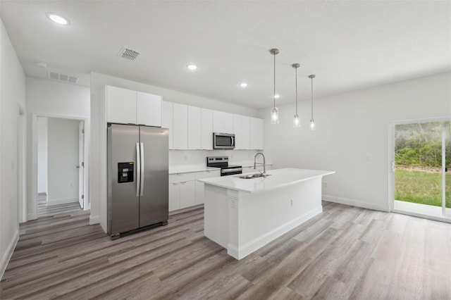 16904 SW 30th Avenue Rd, Ocala, FL 34473 - kitchen with appliances with stainless steel finishes, light wood-type flooring, a sink, a center island with sink, and white cabinetry