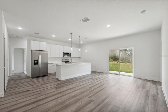 16904 SW 30th Avenue Rd, Ocala, FL 34473 - kitchen with stainless steel appliances, open floor plan, white cabinetry, light wood-style floors, and recessed lighting