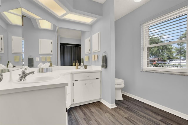 409 Jumper Dr S, Bushnell, FL 33513 - full bathroom with toilet, double vanity, wood finished floors, and baseboards