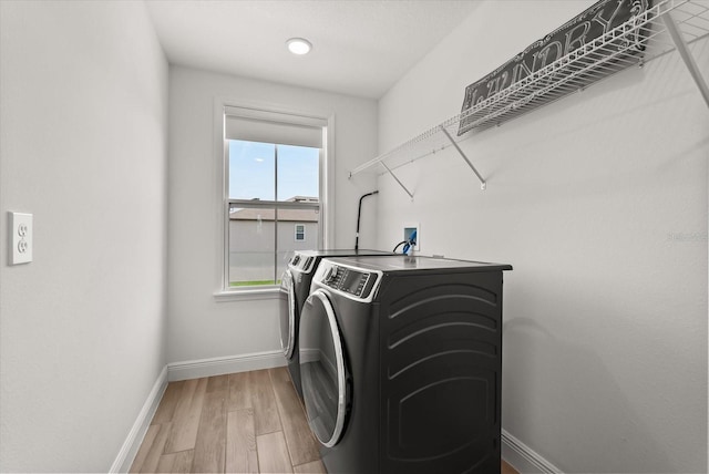 5700 Iron Brand Rd, Saint Cloud, FL 34771 - washroom with separate washer and dryer, baseboards, and light wood-style flooring
