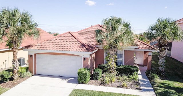 156 Carrera Ave, Davenport, FL 33897 - mediterranean / spanish home with cooling unit, a tile roof, concrete driveway, an attached garage, and stucco siding