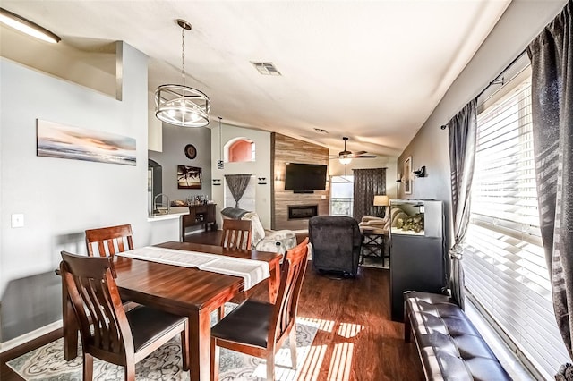 156 Carrera Ave, Davenport, FL 33897 - dining room with vaulted ceiling, dark wood-style flooring, a ceiling fan, and a fireplace