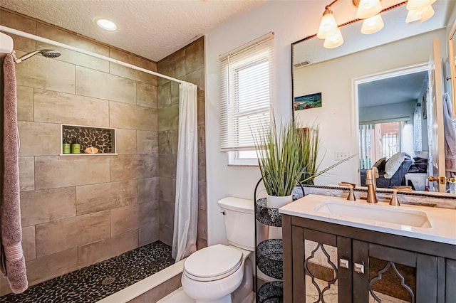 156 Carrera Ave, Davenport, FL 33897 - bathroom featuring toilet, a textured ceiling, vanity, a tile shower, and healthy amount of natural light