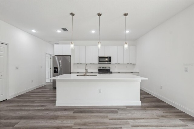 6062 SW 154th Pl, Ocala, FL 34473 - kitchen with stainless steel appliances, a sink, recessed lighting, a center island with sink, and white cabinets