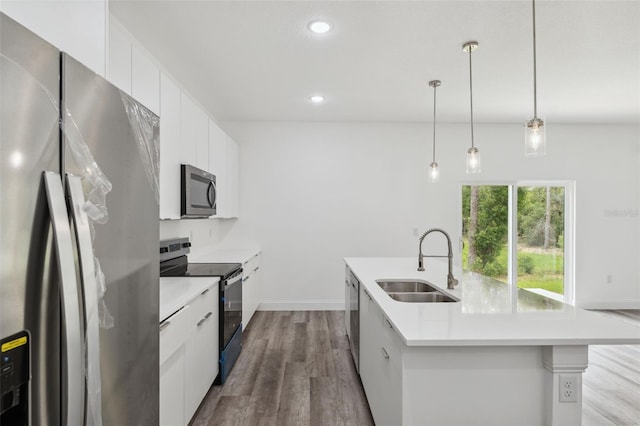 6062 SW 154th Pl, Ocala, FL 34473 - kitchen featuring appliances with stainless steel finishes, a sink, dark wood-style floors, an island with sink, and light countertops