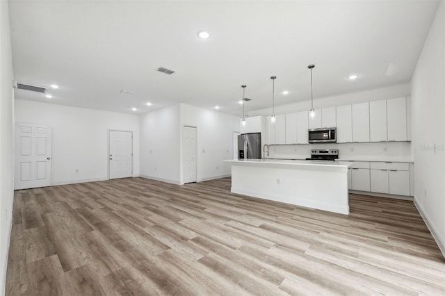 6062 SW 154th Pl, Ocala, FL 34473 - kitchen with appliances with stainless steel finishes, recessed lighting, open floor plan, and white cabinets