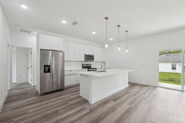 6062 SW 154th Pl, Ocala, FL 34473 - kitchen with appliances with stainless steel finishes, a sink, light wood-style flooring, white cabinetry, and recessed lighting