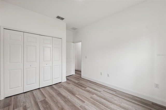 6062 SW 154th Pl, Ocala, FL 34473 - unfurnished bedroom with light wood-style floors, a closet, and baseboards