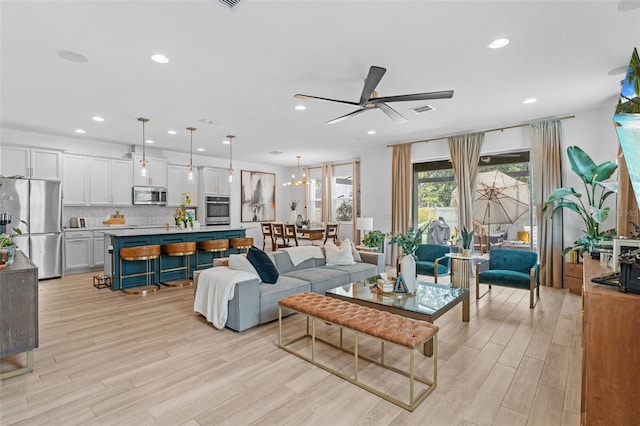 1425 Paget Cv, Sanford, FL 32771 - living room with a ceiling fan, light wood-style flooring, recessed lighting, and a chandelier