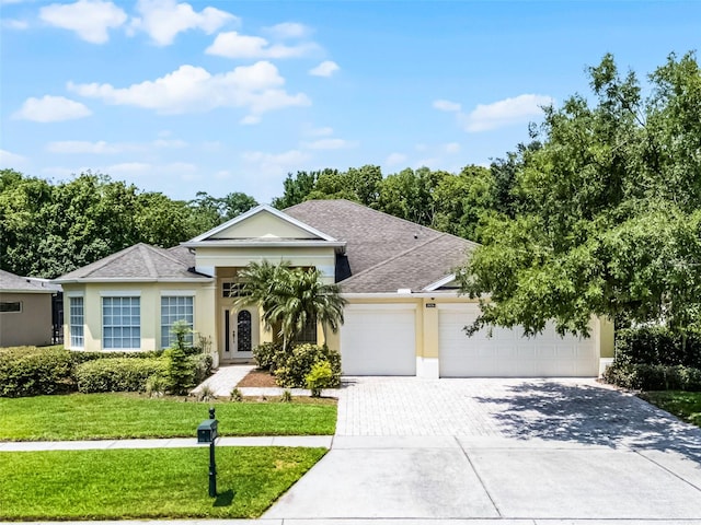 2026 Winding Oaks Dr, Orlando, FL 32825 - ranch-style home featuring a garage, driveway, a front yard, and stucco siding