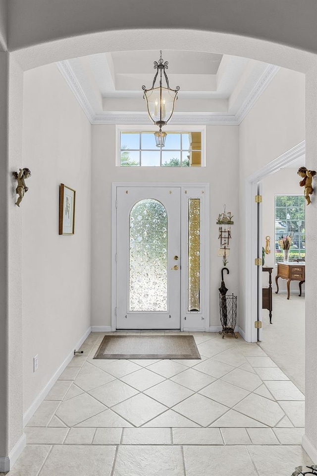 2026 Winding Oaks Dr, Orlando, FL 32825 - foyer featuring a chandelier, a towering ceiling, a raised ceiling, ornamental molding, and arched walkways