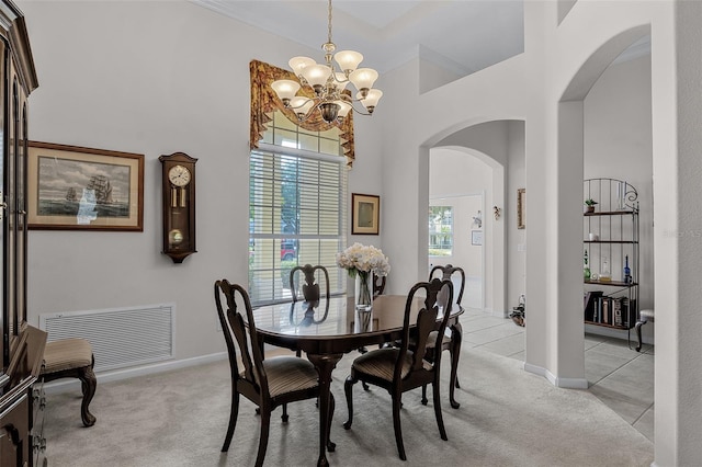 2026 Winding Oaks Dr, Orlando, FL 32825 - dining space with arched walkways, a chandelier, light colored carpet, a high ceiling, and baseboards