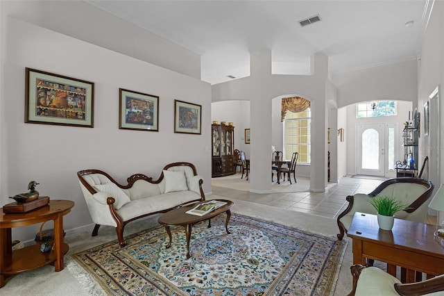 2026 Winding Oaks Dr, Orlando, FL 32825 - living room with arched walkways, ornamental molding, light tile patterned floors, and baseboards
