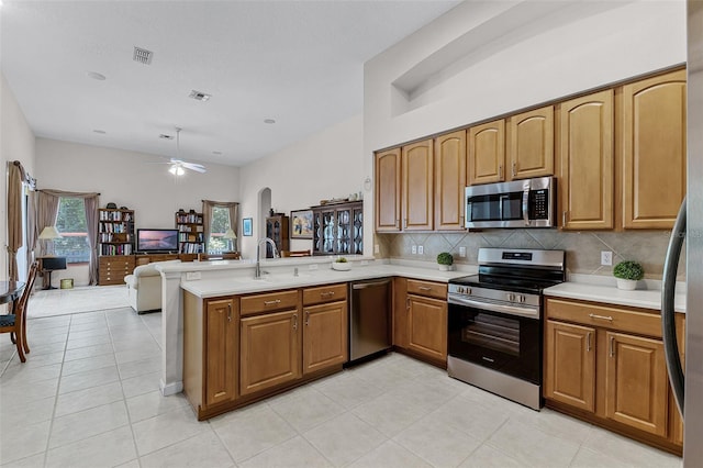 2026 Winding Oaks Dr, Orlando, FL 32825 - kitchen featuring appliances with stainless steel finishes, a peninsula, light countertops, tasteful backsplash, and a sink