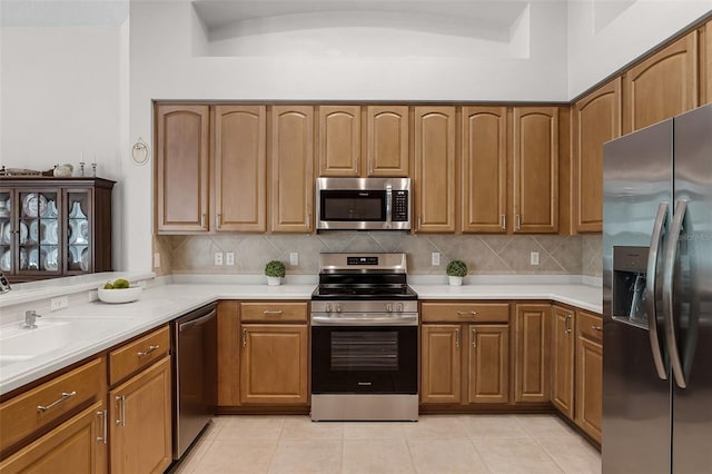 2026 Winding Oaks Dr, Orlando, FL 32825 - kitchen with stainless steel appliances, decorative backsplash, light countertops, and brown cabinetry