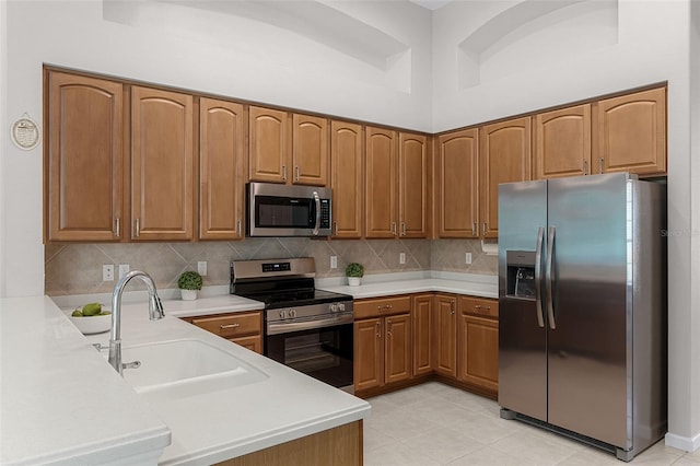 2026 Winding Oaks Dr, Orlando, FL 32825 - kitchen featuring appliances with stainless steel finishes, a sink, brown cabinetry, and light countertops