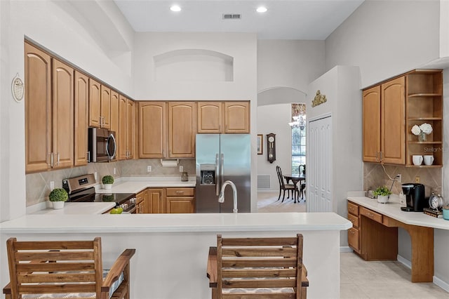 2026 Winding Oaks Dr, Orlando, FL 32825 - kitchen featuring appliances with stainless steel finishes, open shelves, light countertops, a peninsula, and decorative backsplash