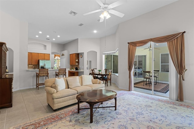 2026 Winding Oaks Dr, Orlando, FL 32825 - living room featuring a ceiling fan, arched walkways, a high ceiling, light tile patterned flooring, and baseboards