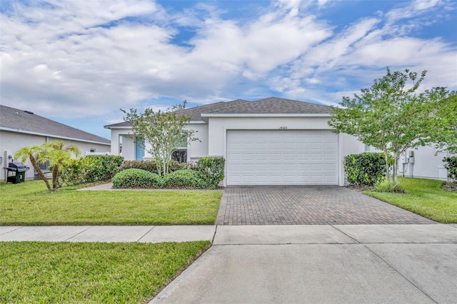 14325 Hidden Ct, Clermont, FL 34711 - view of front facade featuring decorative driveway, stucco siding, an attached garage, and a front lawn