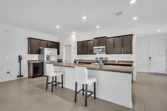 14325 Hidden Ct, Clermont, FL 34711 - kitchen featuring stainless steel appliances, a sink, dark brown cabinets, recessed lighting, and a kitchen breakfast bar