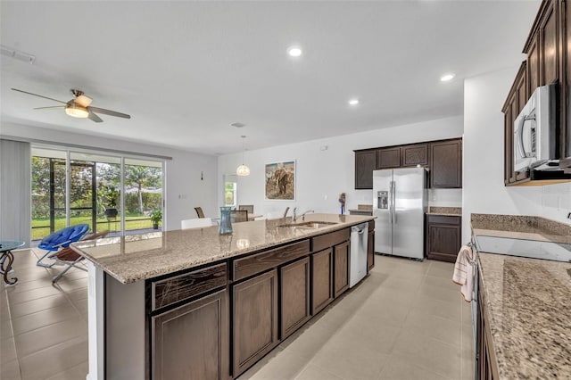14325 Hidden Ct, Clermont, FL 34711 - kitchen featuring appliances with stainless steel finishes, a sink, an island with sink, ceiling fan, and light stone counters