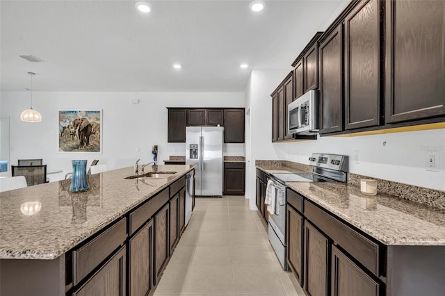 14325 Hidden Ct, Clermont, FL 34711 - kitchen with appliances with stainless steel finishes, a sink, dark brown cabinetry, light stone counters, and recessed lighting