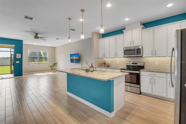 2936 Econ Landing Blvd, Orlando, FL 32825 - kitchen featuring appliances with stainless steel finishes, decorative backsplash, white cabinets, open floor plan, and recessed lighting