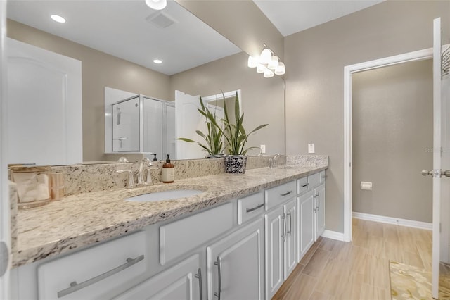 2936 Econ Landing Blvd, Orlando, FL 32825 - bathroom with double vanity, baseboards, a shower stall, wood finished floors, and recessed lighting